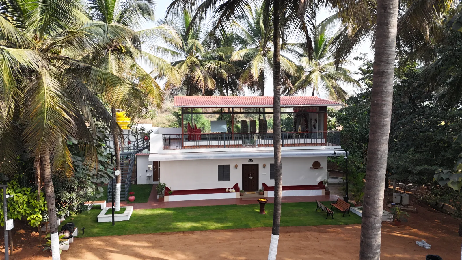 Aerial view of Amal Farms farmhouse surrounded by coconut trees